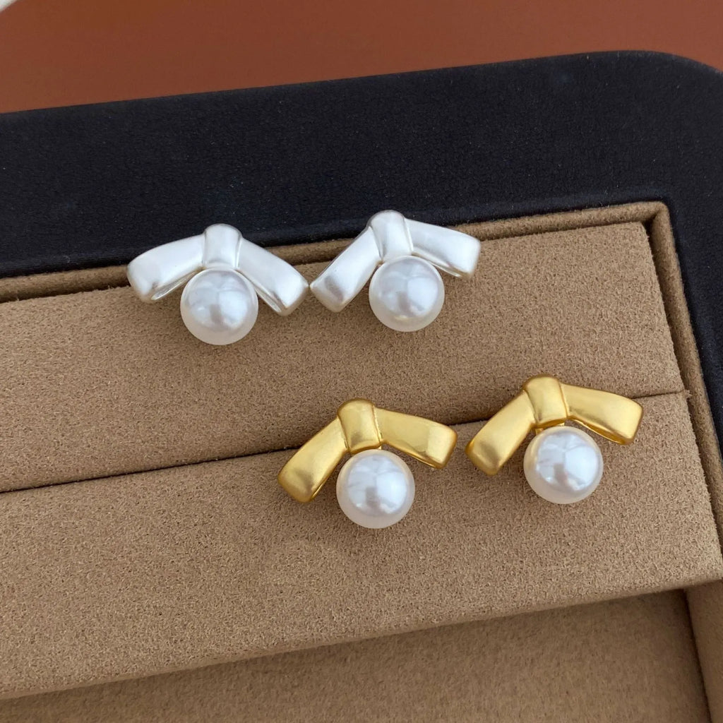 Matte bow earrings for women in matte gold clip-on style on a white background