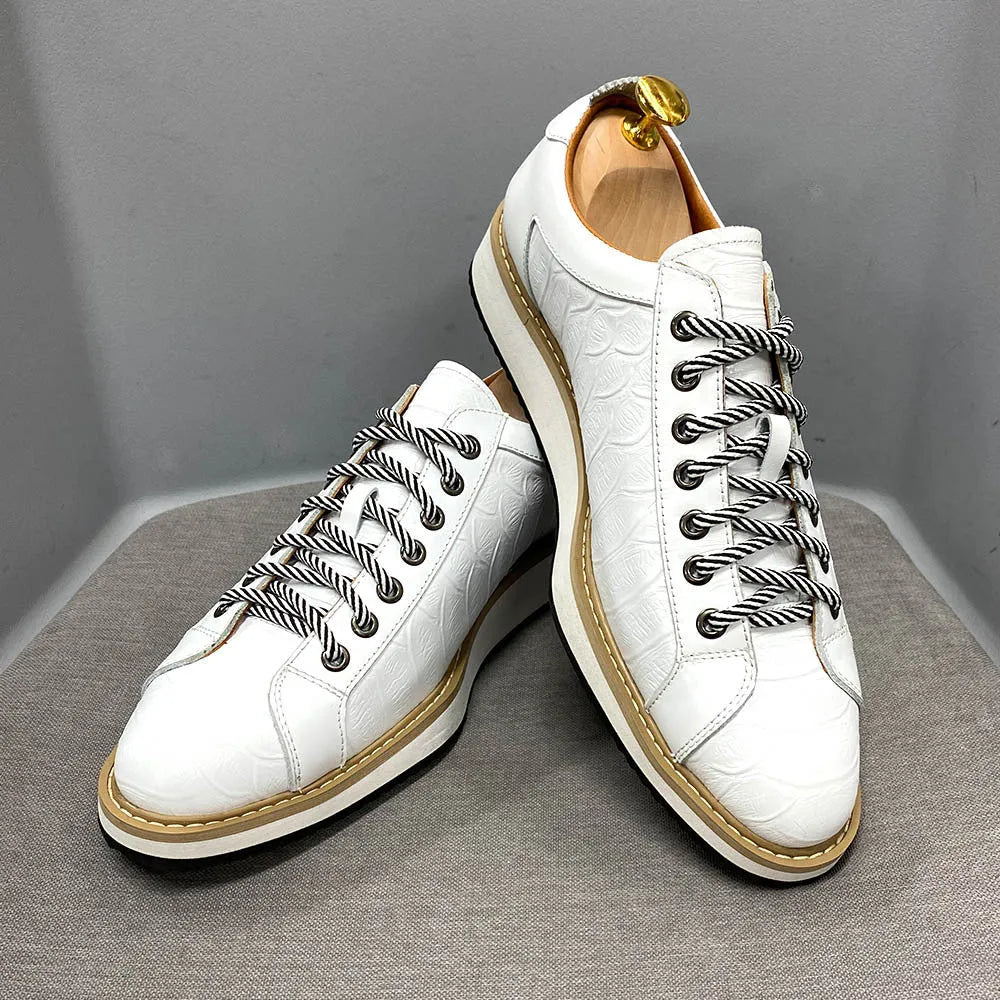 Men's low-top handmade shoes with embossed pattern detail on the upper and front lace closure.