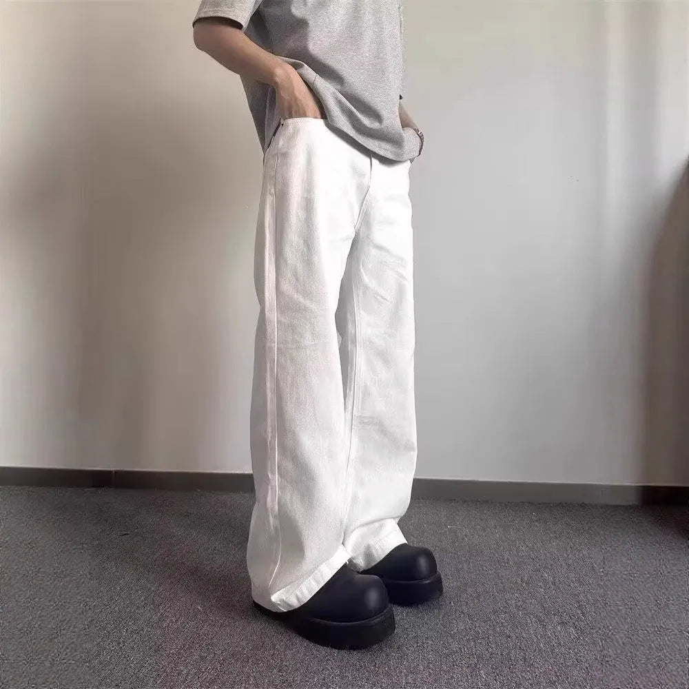 Men's white straight-leg denim jeans with a wide fit and mid-rise waist on a plain background.