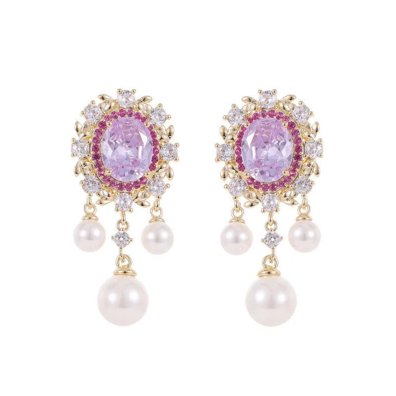 Pair of oval copper earrings with inlaid zircon and a white pearl tassel drop.
