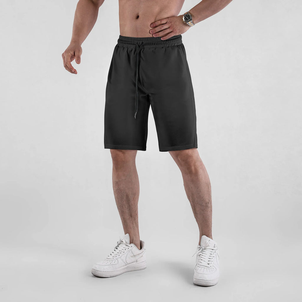 Man wearing black quick-dry mesh capri shorts with a loose, casual fit.