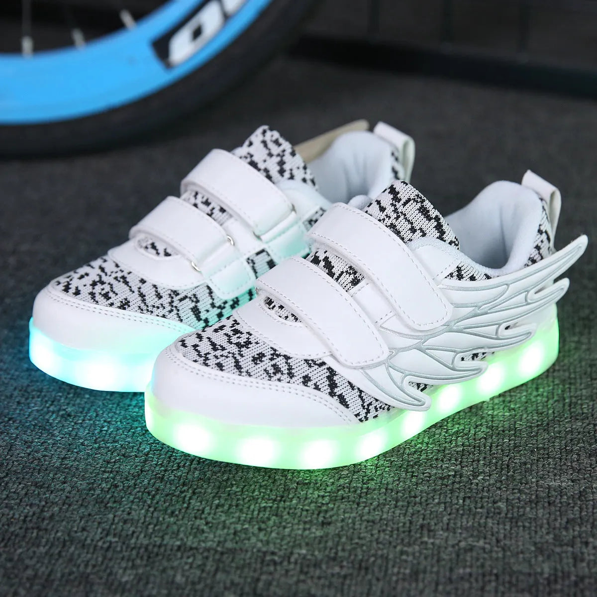 Children's plum red and white LED light-up trainers with colourful wing designs and USB charging port.