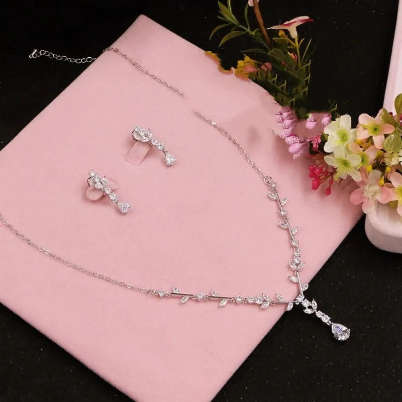 Simple bridal silver alloy love pattern necklace and earrings suite on display, handmade ornament set with ear clip option