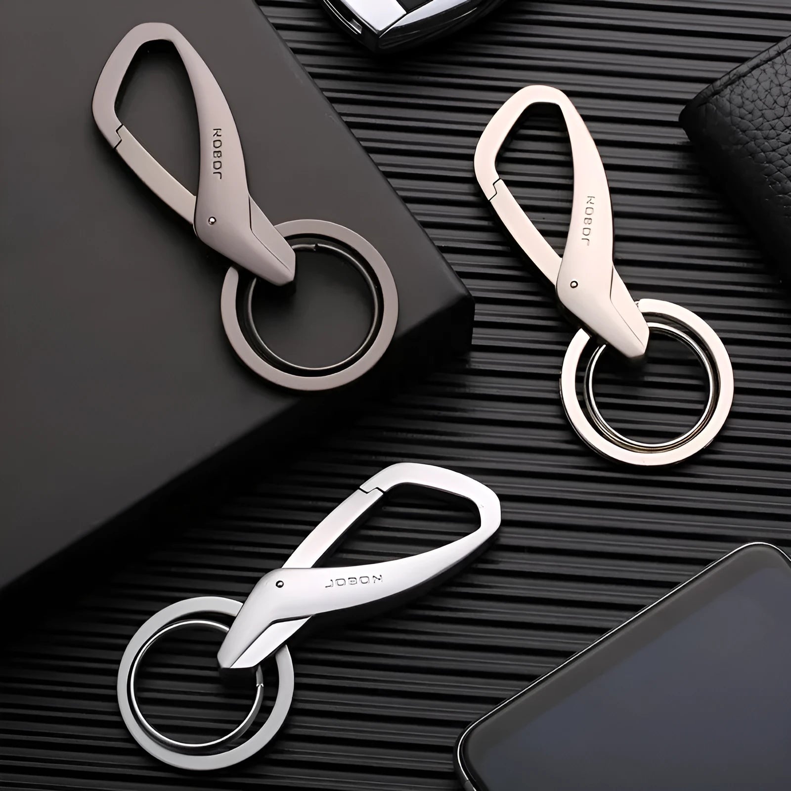 Black zinc alloy rectangular key chain with a carabiner clip and double ring, shown next to a set of keys for scale.