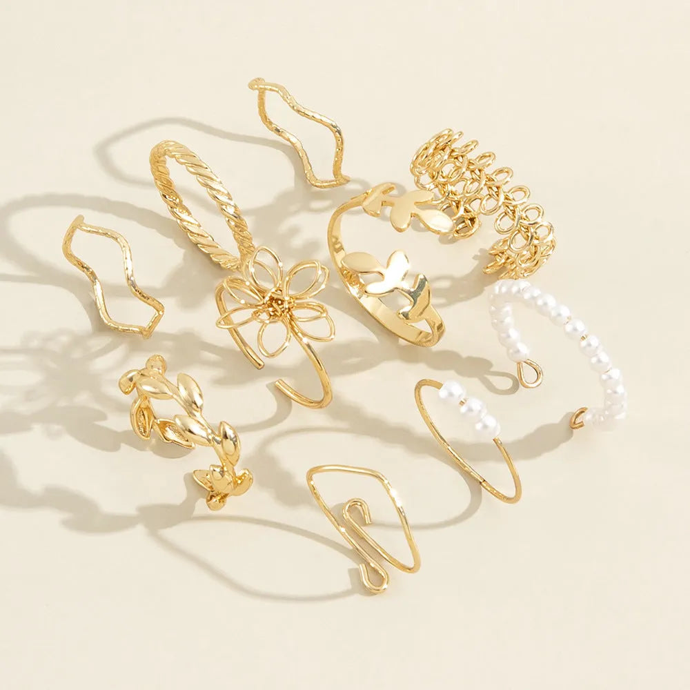 Gold openwork flower alloy ring with glossy electroplated finish on white background