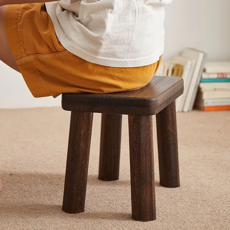 Solid wood household stool with distressed finish, shown as a changing stool or footrest.