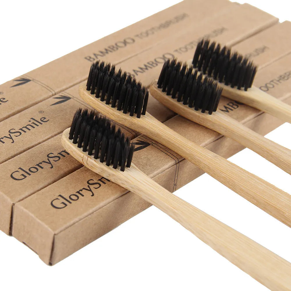 Natural bamboo toothbrush with black charcoal bristles on a white background