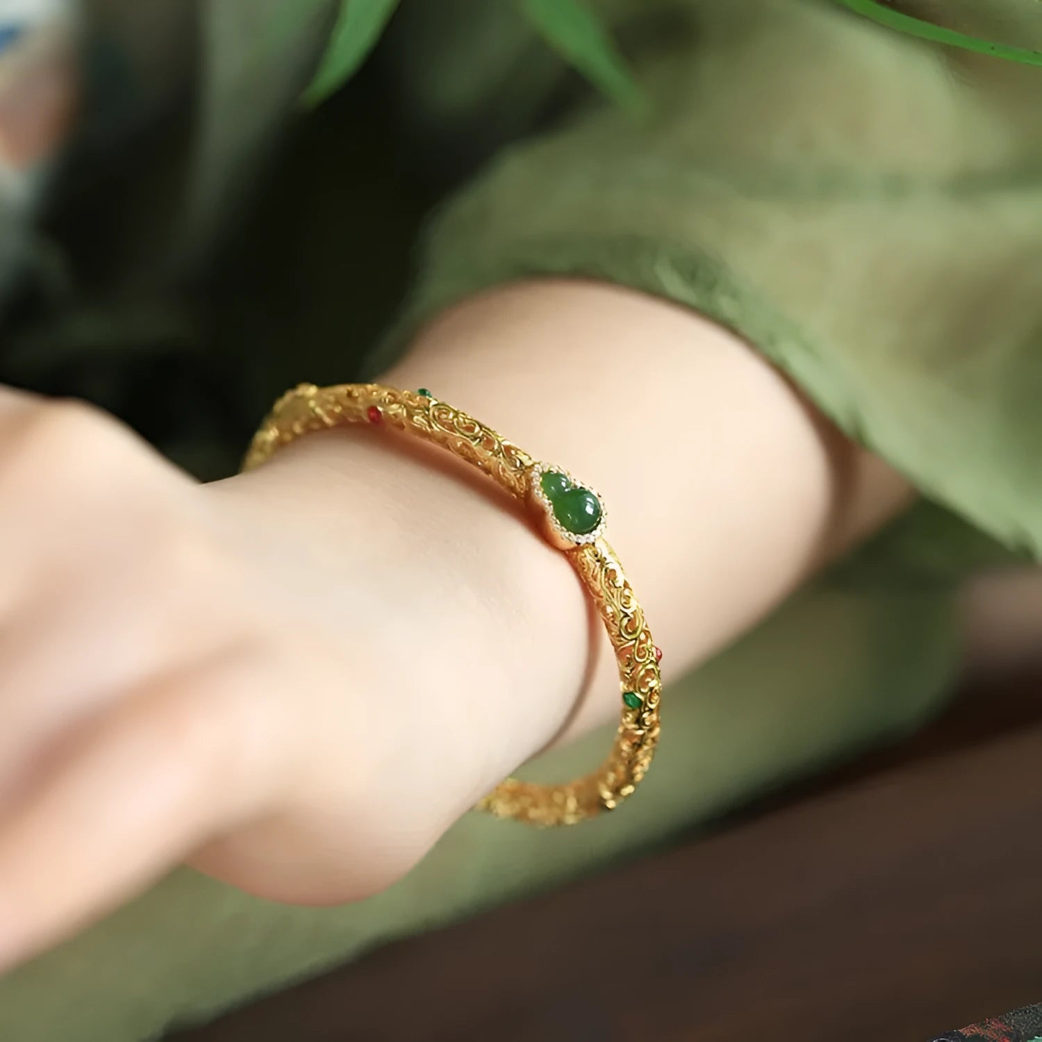 Retro-style open copper bracelet with a detailed gourd charm on a wrist.