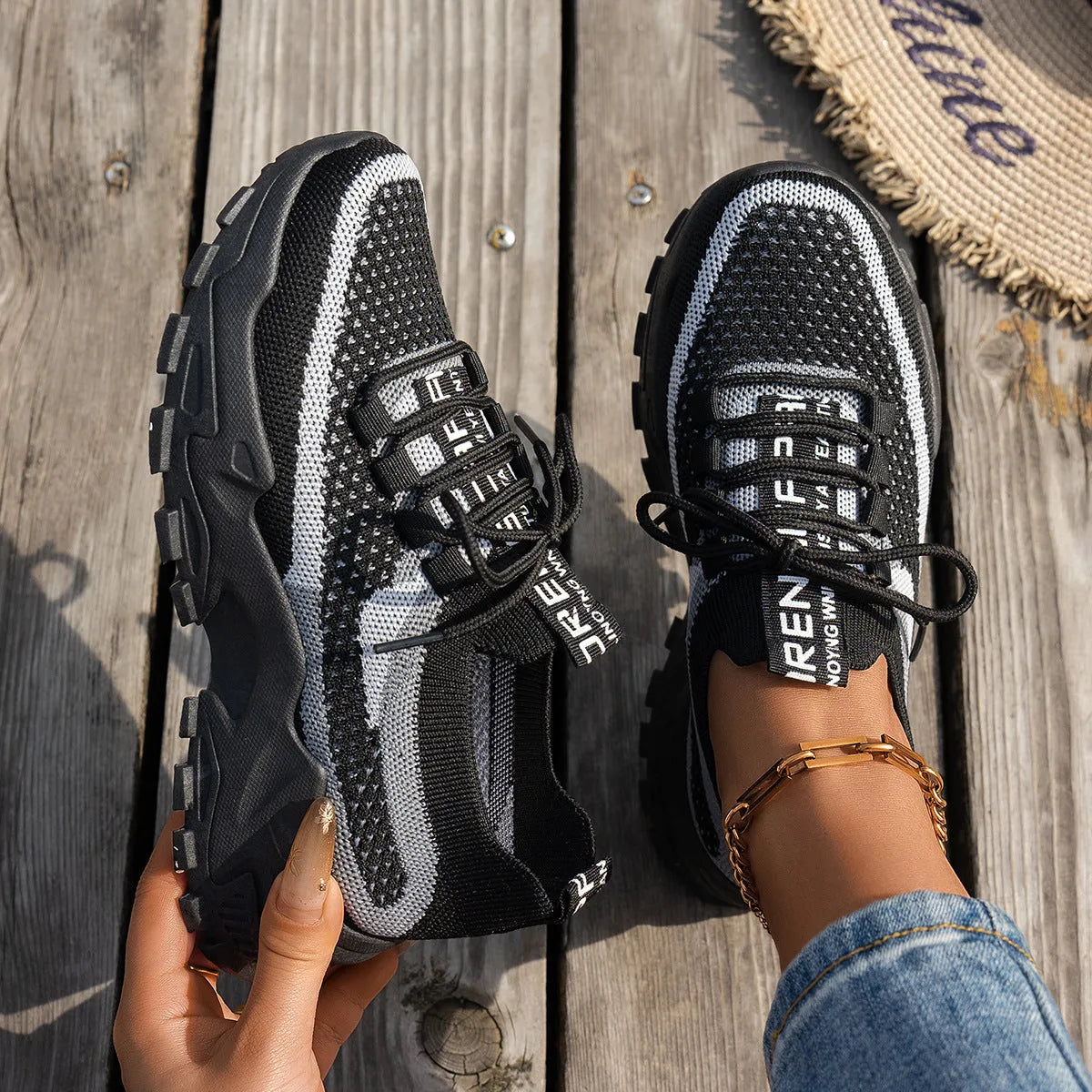 Women's Flyknit mesh lace-up sneakers in grey and white colour combination on a flat rubber sole.
