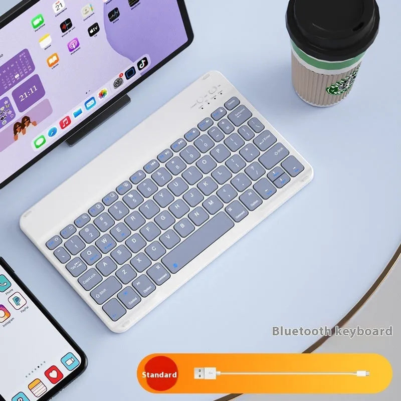 Bluetooth keyboard and matching rechargeable mouse set in elegant pink colour on a desk next to a tablet.