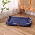 Grey waterproof dog sofa bed with cushioned sides on a wooden floor.