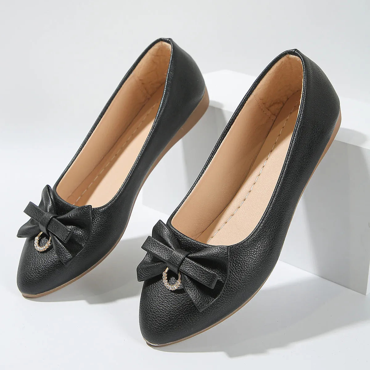 Women's beige casual flat shoes with a bowknot detail on the artificial PU upper.