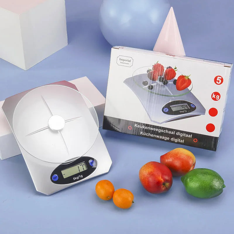 Simple mini kitchen electronic scale in silver white colour on a flat surface, showing weighing display.