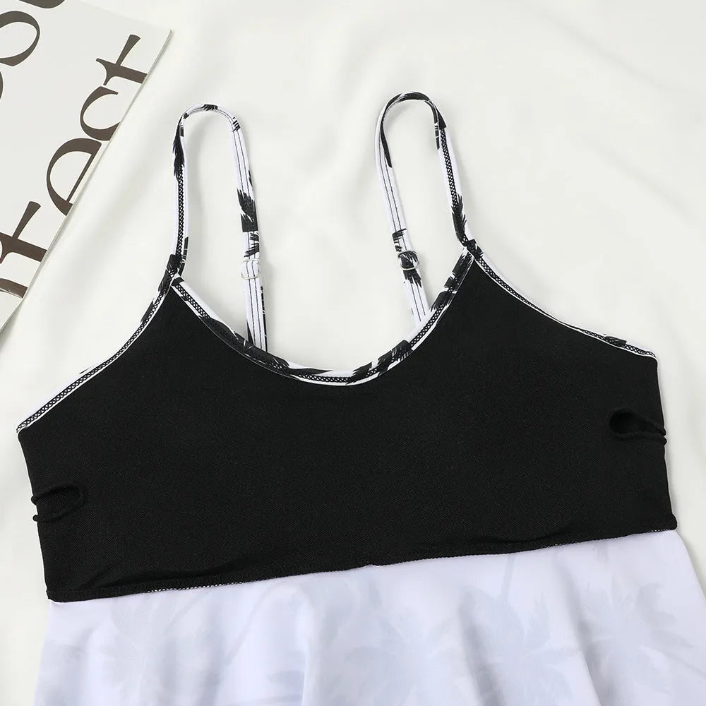 Black high waist swimsuit briefs and sleeveless top with coconut tree print, laid flat.