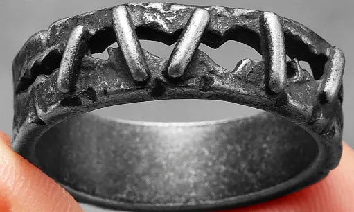 Dark punk style stainless steel double band ring on a hand, showing textured stitching detail.