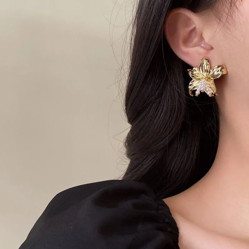 Golden metal flower earrings with exaggerated design and personalised pearl elements