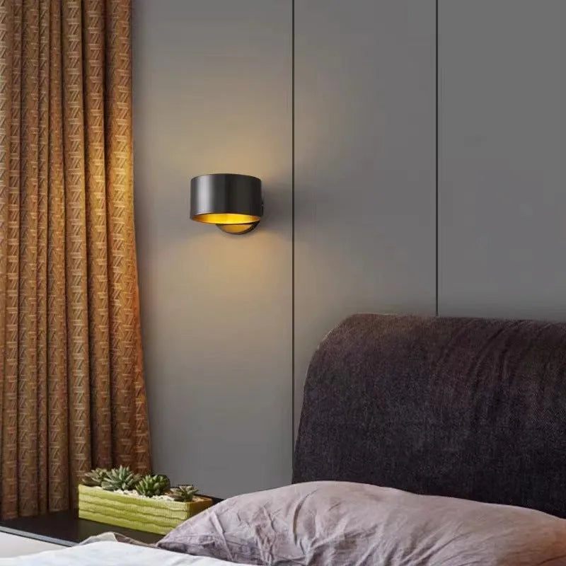 A modern simplistic copper wall lamp shown in a living room setting.