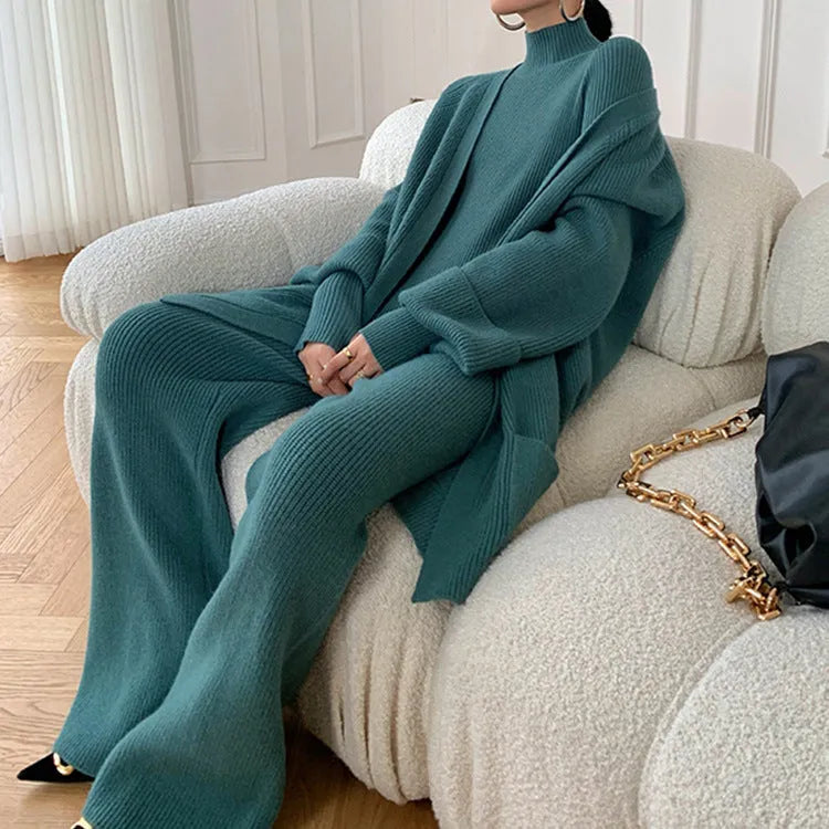 Women's apricot knitted three-piece set with wide-leg trousers, top, and long cardigan on a hanger.