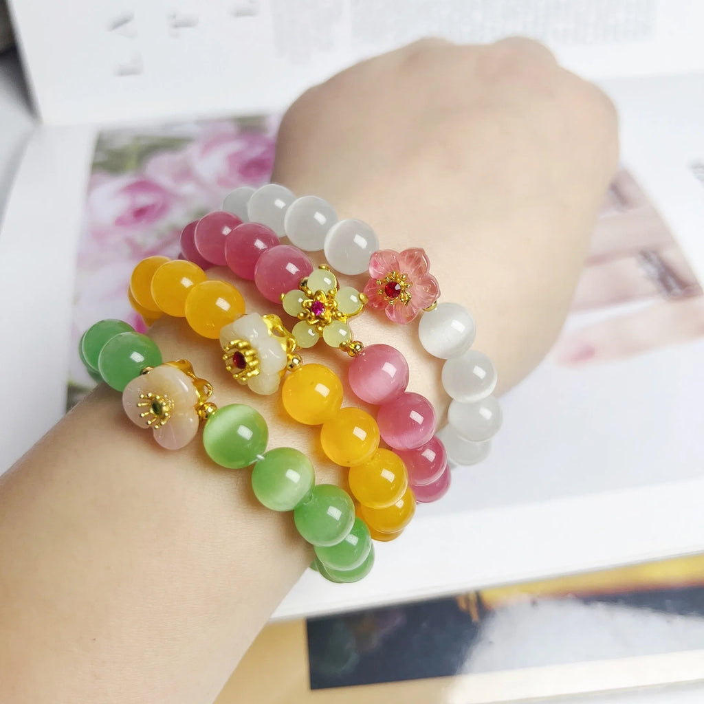 Handmade glass bead bracelet with floral design in green, pink, white, or yellow.