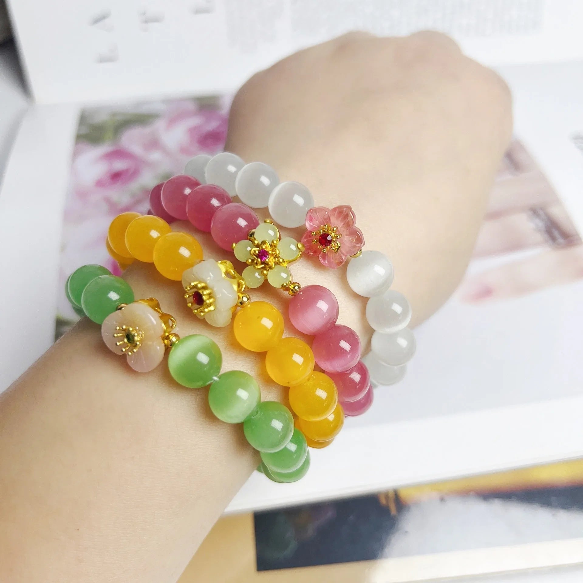 Handmade glass bead bracelet with floral design in green, pink, white, or yellow.