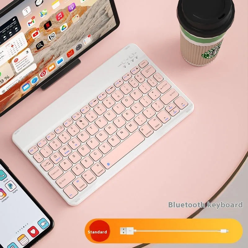 Bluetooth keyboard and matching rechargeable mouse set in elegant pink colour on a desk next to a tablet.