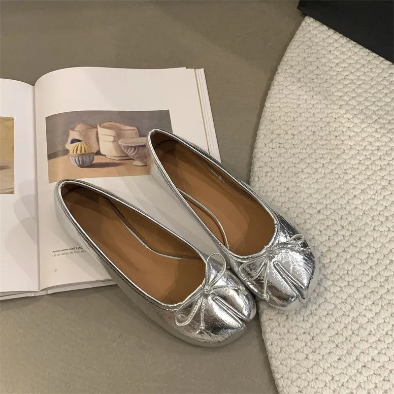 Women's flat split-toe pumps in beige with round toe and rubber sole.