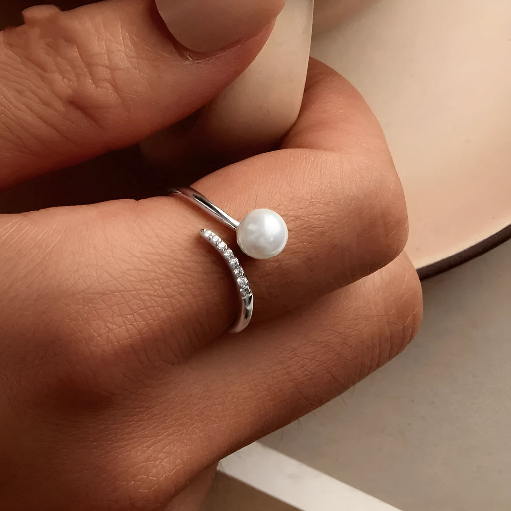 Close-up of an adjustable S925 sterling silver ring featuring a natural shell pearl on an open loop band.