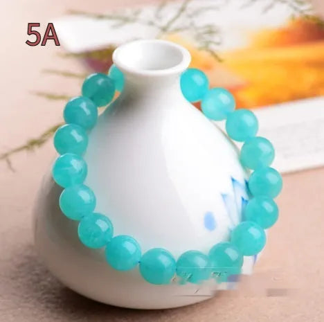 Selection of natural green Amazonite scattered beads in different sizes on a white background.