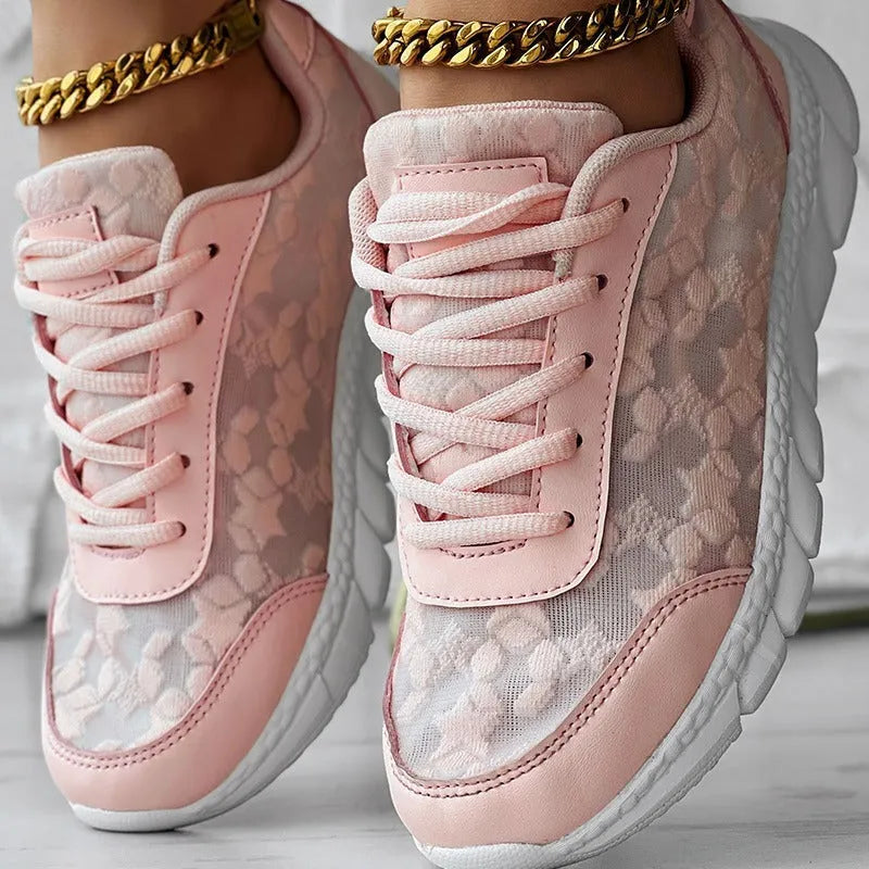 Women's white canvas running shoes with a round toe, flat heel, and soft sole on a neutral background.