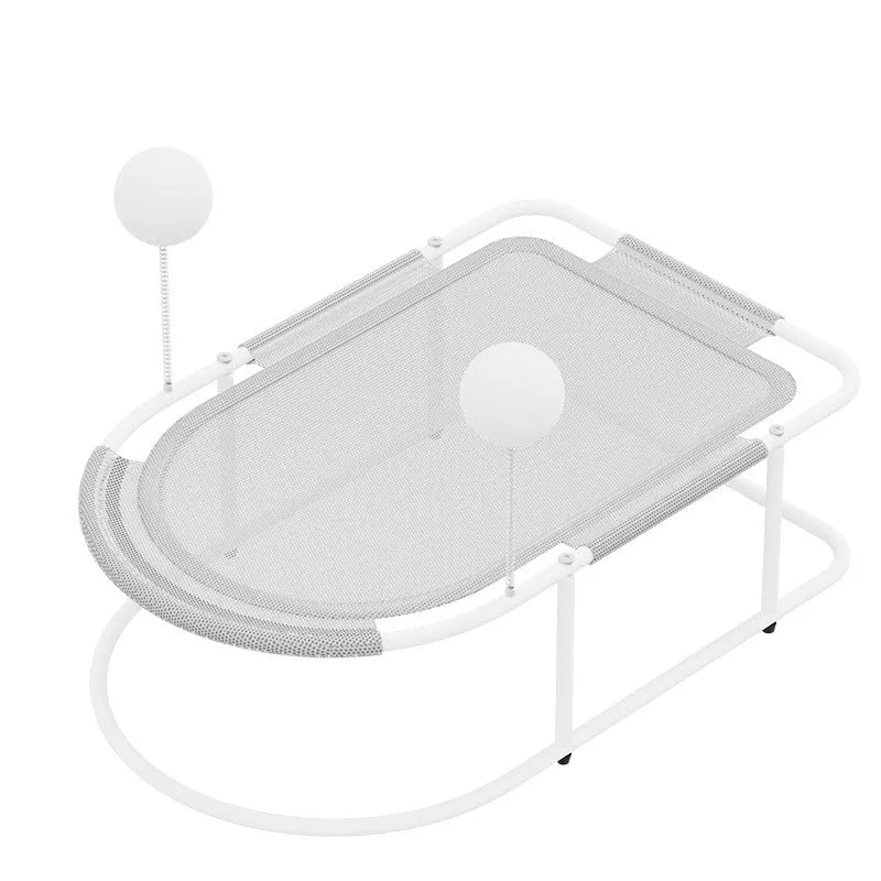 Grey fabric cat kennel with open sides and a round, removable floor pad on a carpet.