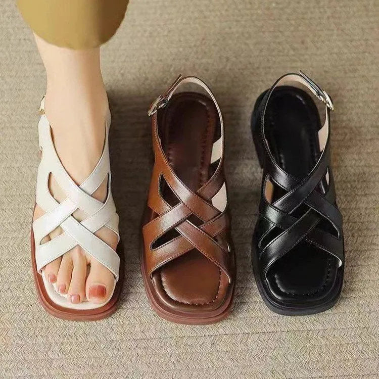 Women's glossy patent leather square toe sandals with a cross-strap design in black.