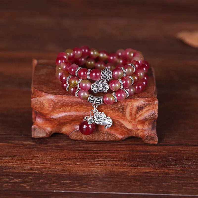 Handcrafted watermelon crystal bracelet with Chinese knot design showing 8mm elephant-style beads