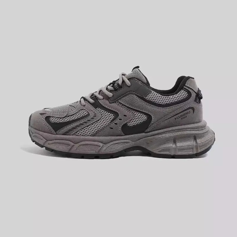 Grey chunky platform sneakers with leather stitching and lace-up design on a white background.