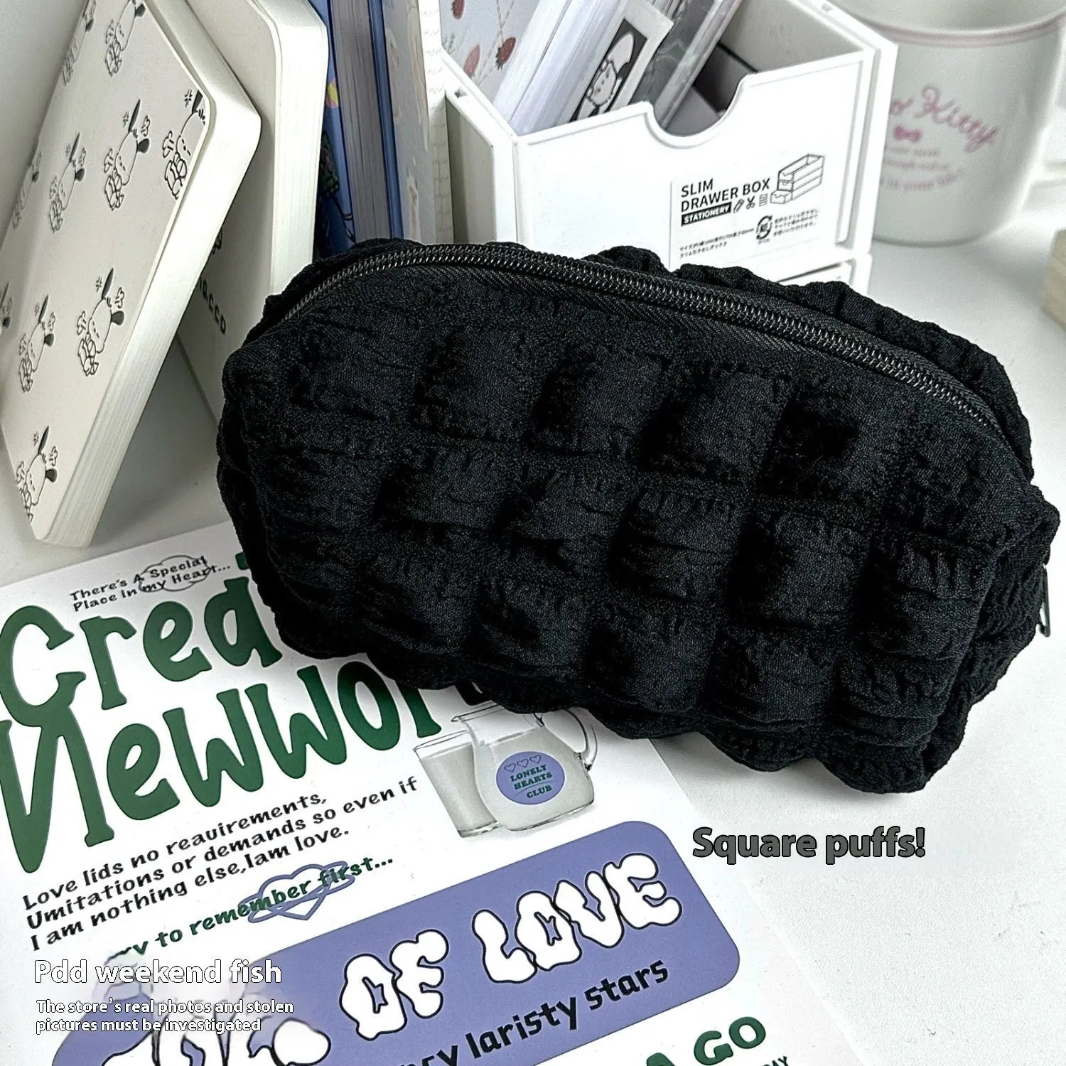 Beige and black fabric pencil case with cream puff design for organising pens and stationery.