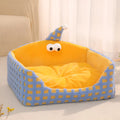 Green triangular pet sleeping nest with removable cover for cats and small dogs.