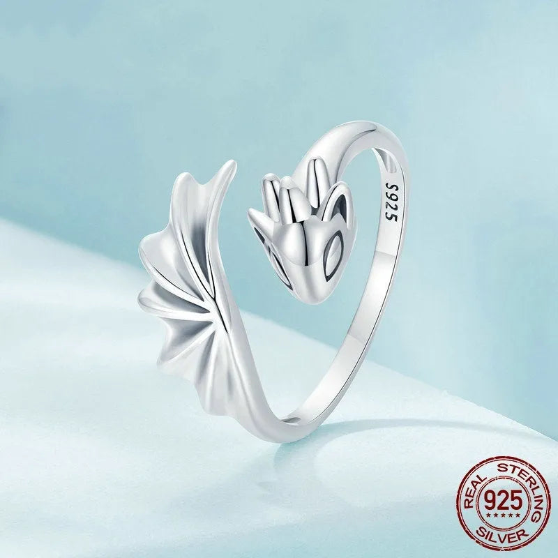 Unisex silver adjustable open ring with flying dragon wing motif on neutral background