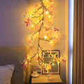 Flexible LED butterfly tree rattan lamp shaped into a decorative spiral, showing USB cable and lit white LEDs.