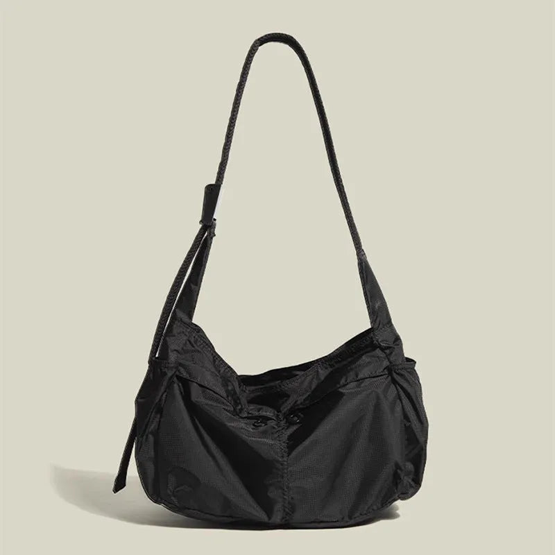Large black nylon waterproof messenger bag with shoulder strap showing horizontal square shape