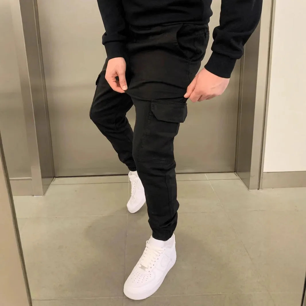 Man wearing loose-fit light blue casual trousers with a patch pocket and elasticated lace waistband
