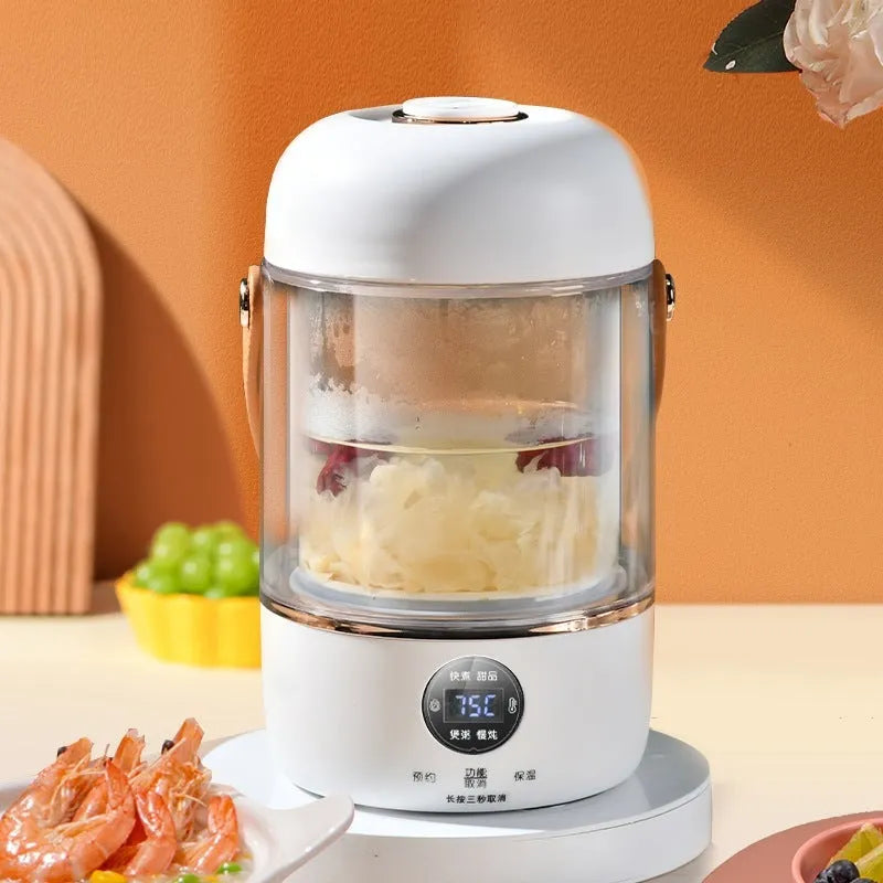 Personal portable electric stew cooker with transparent glass pot and fibreglass body on a desk.