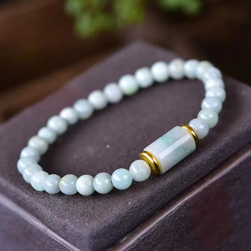 Close-up of a natural emerald green Myanmar jade stone bracelet with round lucky beads on a wrist.