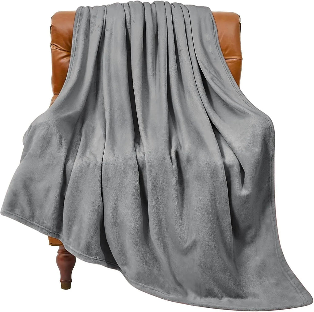 Light gray coral flannel polyester air conditioning blanket folded on a neutral background
