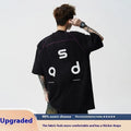 Man's black cotton T-shirt with a white letter print, showing loose fit and short sleeves.