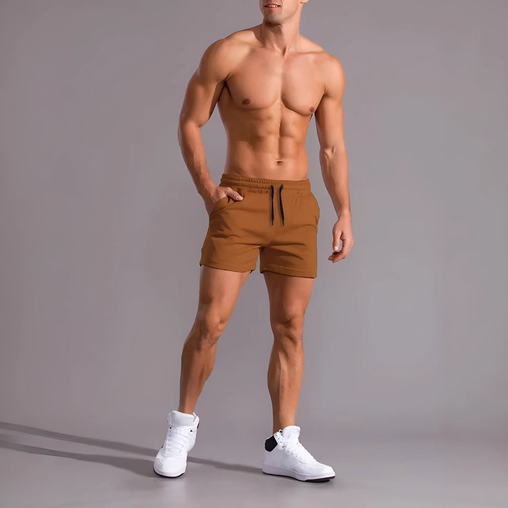 Three pairs of men's solid colour casual shorts with drawstring waistbands, shown in black, khaki, and light brown.