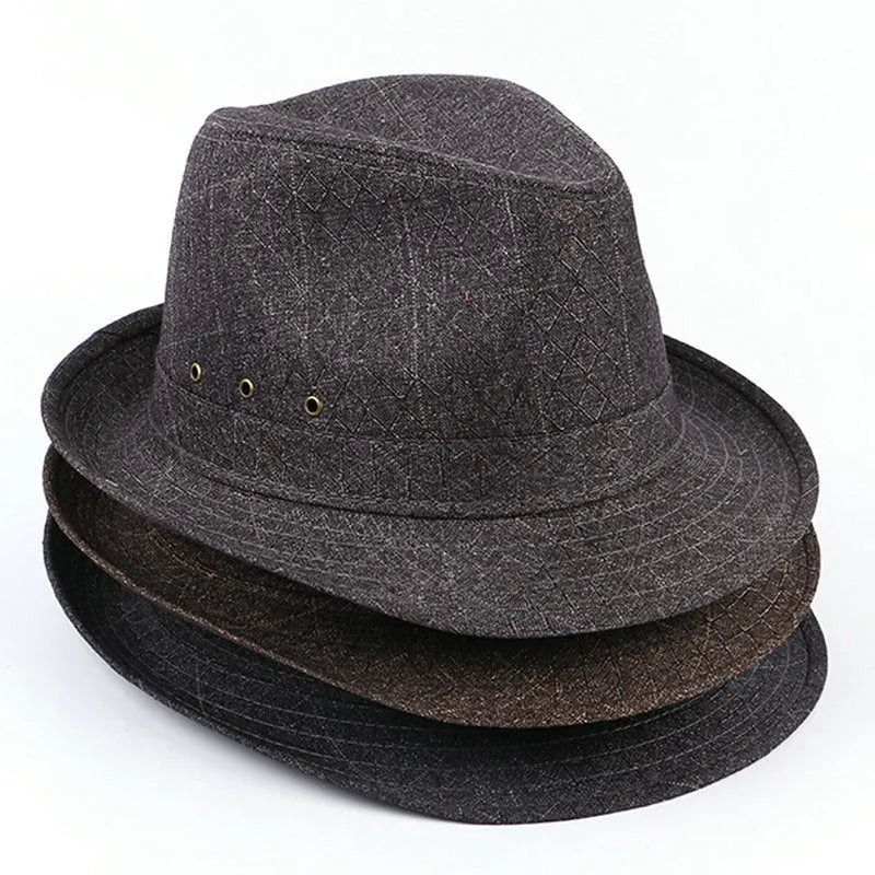 A man's brown fedora hat with a pinched crown and a medium-width brim on a wooden table.