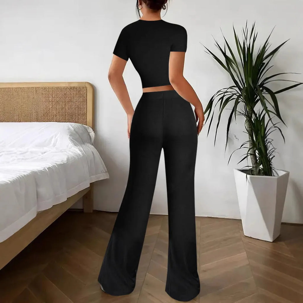 Black women's high waist trousers and short sleeve T-shirt lounge suit set on a plain background.