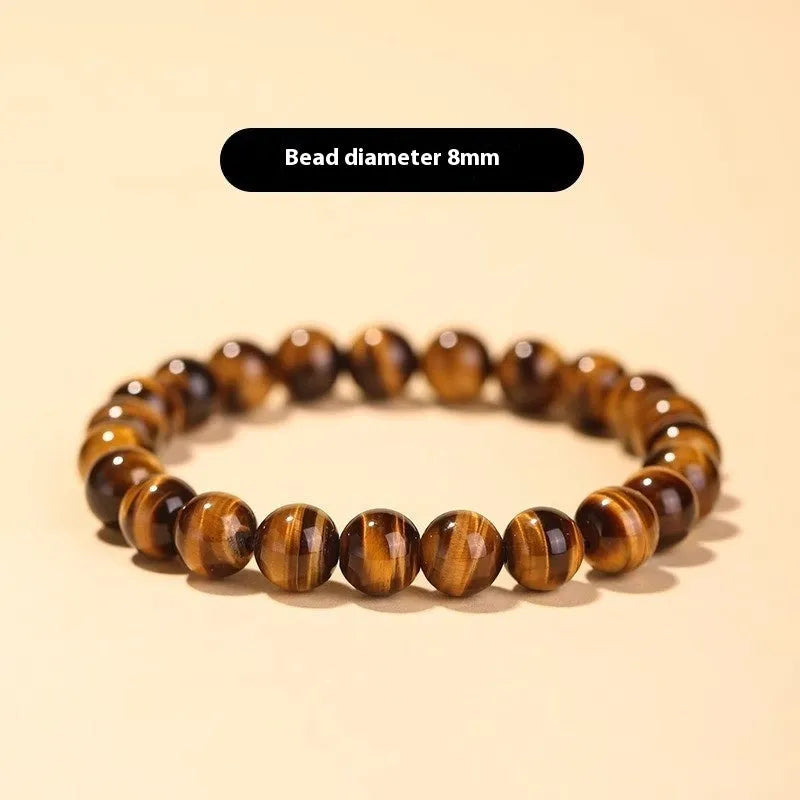 Single strand tigereye Buddha bead bracelet with dzi pattern on wrist, showing 10mm bead size.