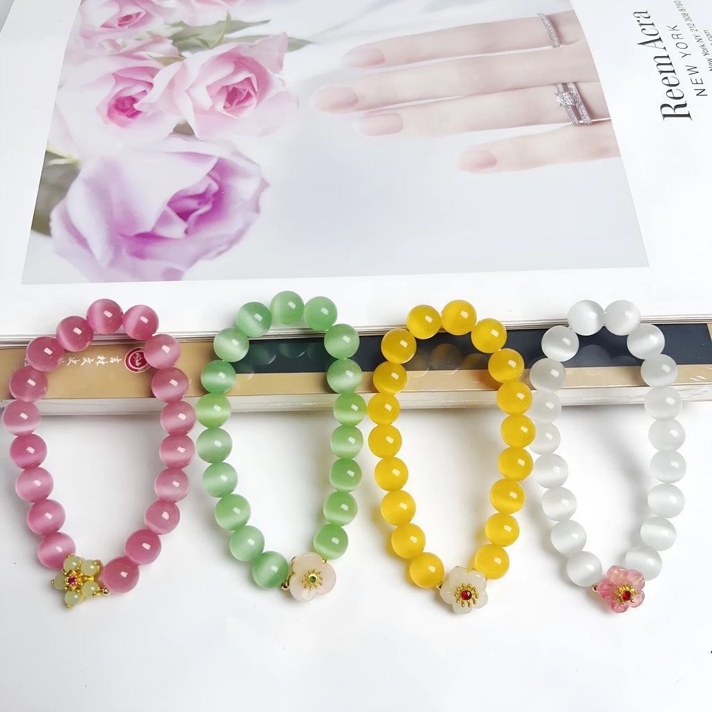 Handmade glass bead bracelet with floral design in green, pink, white, or yellow.
