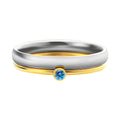 Close-up of a titanium steel engraved ring with a December colour birthstone, showing geometric design.