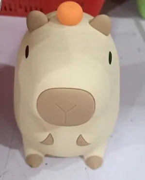 Cute brown Capybara silicone night lamp with soft glow on a bedside table.